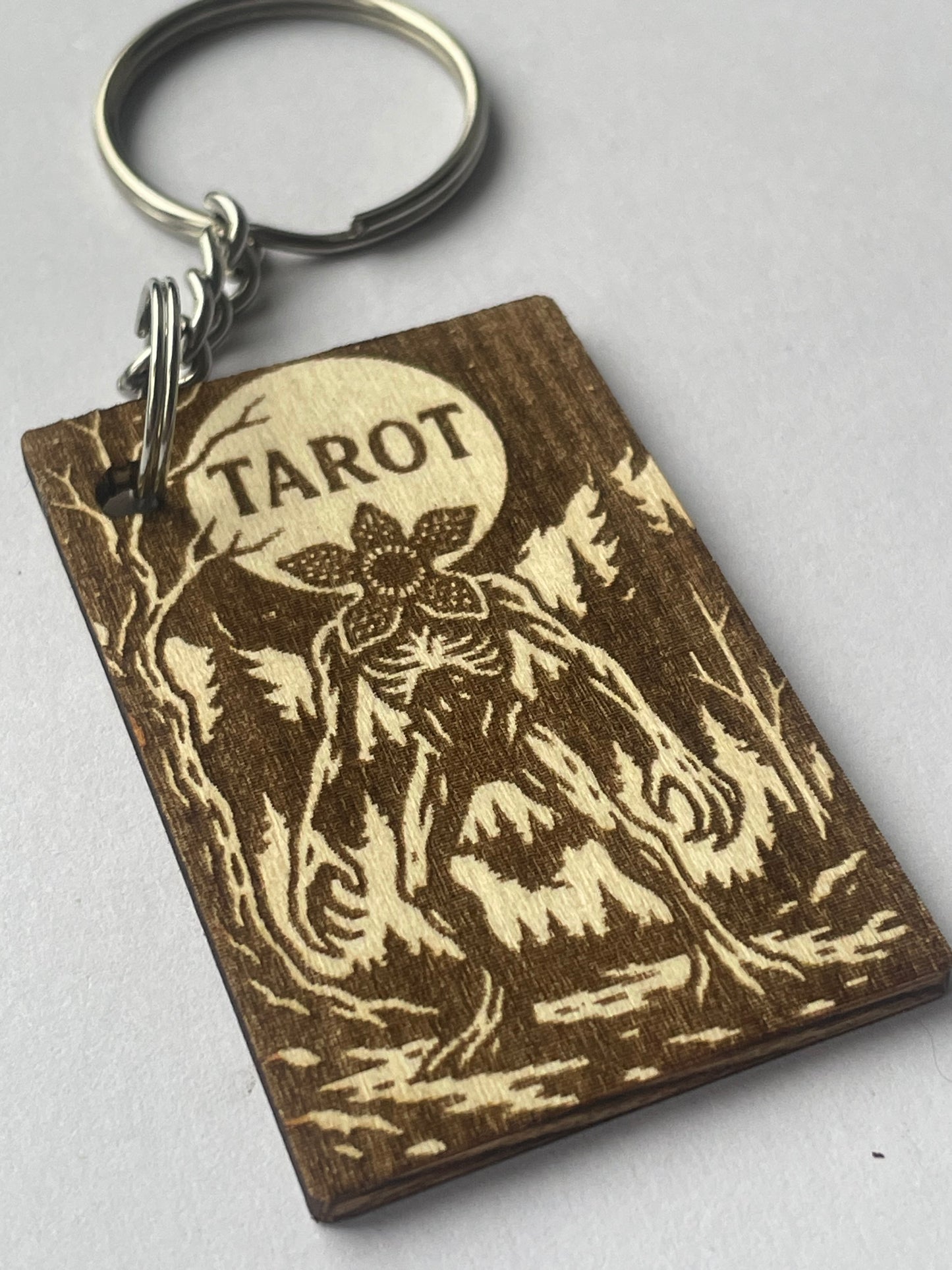 Wooden keychain with 'Tarot' engraving on a gray background