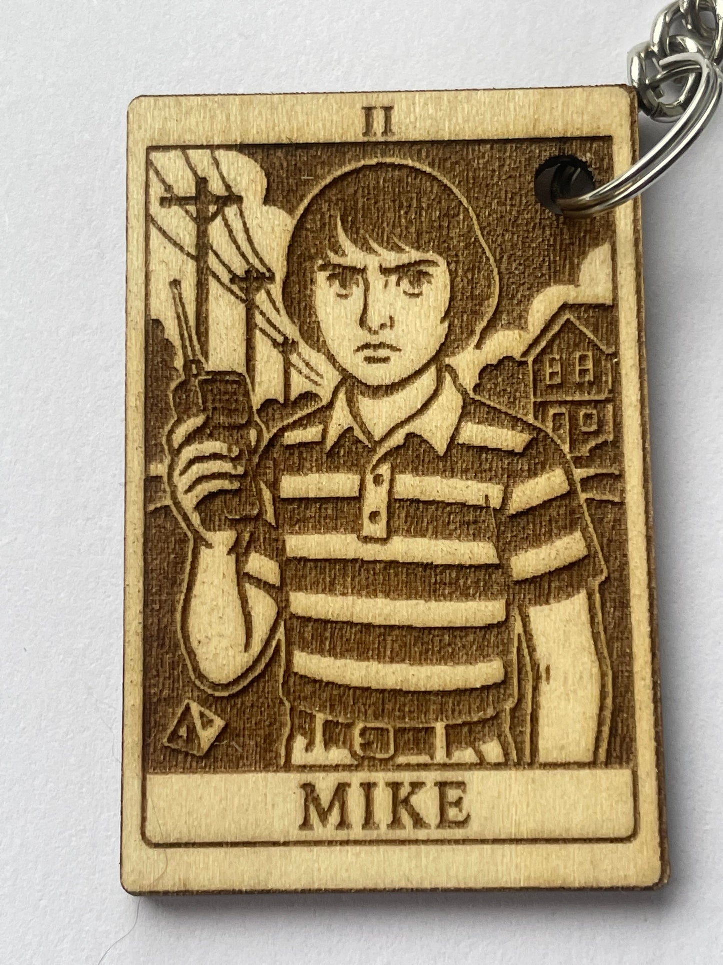 Wooden keychain with engraved design and 'MIKE' text on a white background