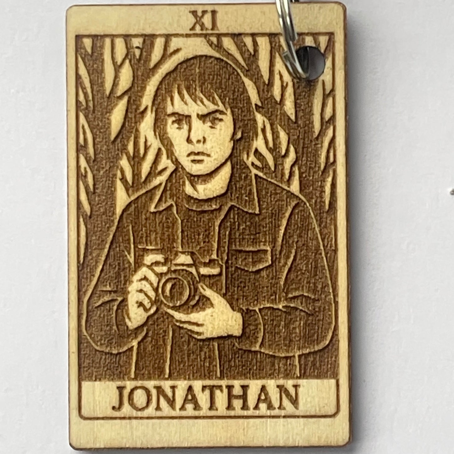 Wooden keychain with engraved design and 'Jonathan' text on a white background