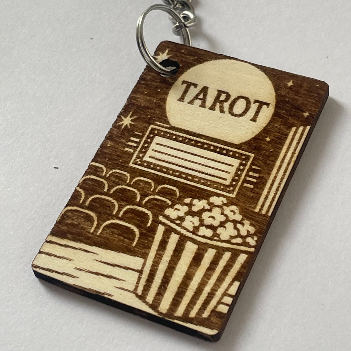 Wooden tarot card keychain with engraved design on a white background
