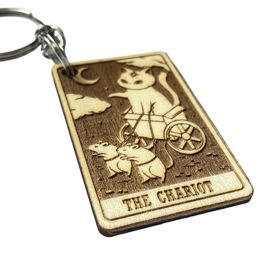 Wooden keychain with 'The Chariot' tarot card design on a light gray background