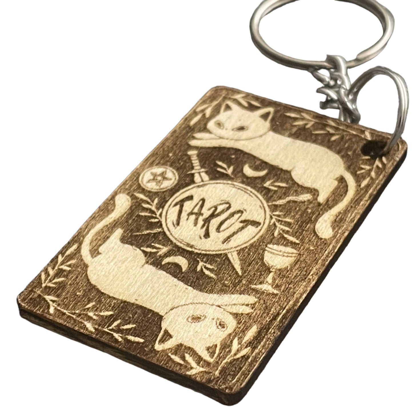 Wooden keychain with cat design on a gray fabric background