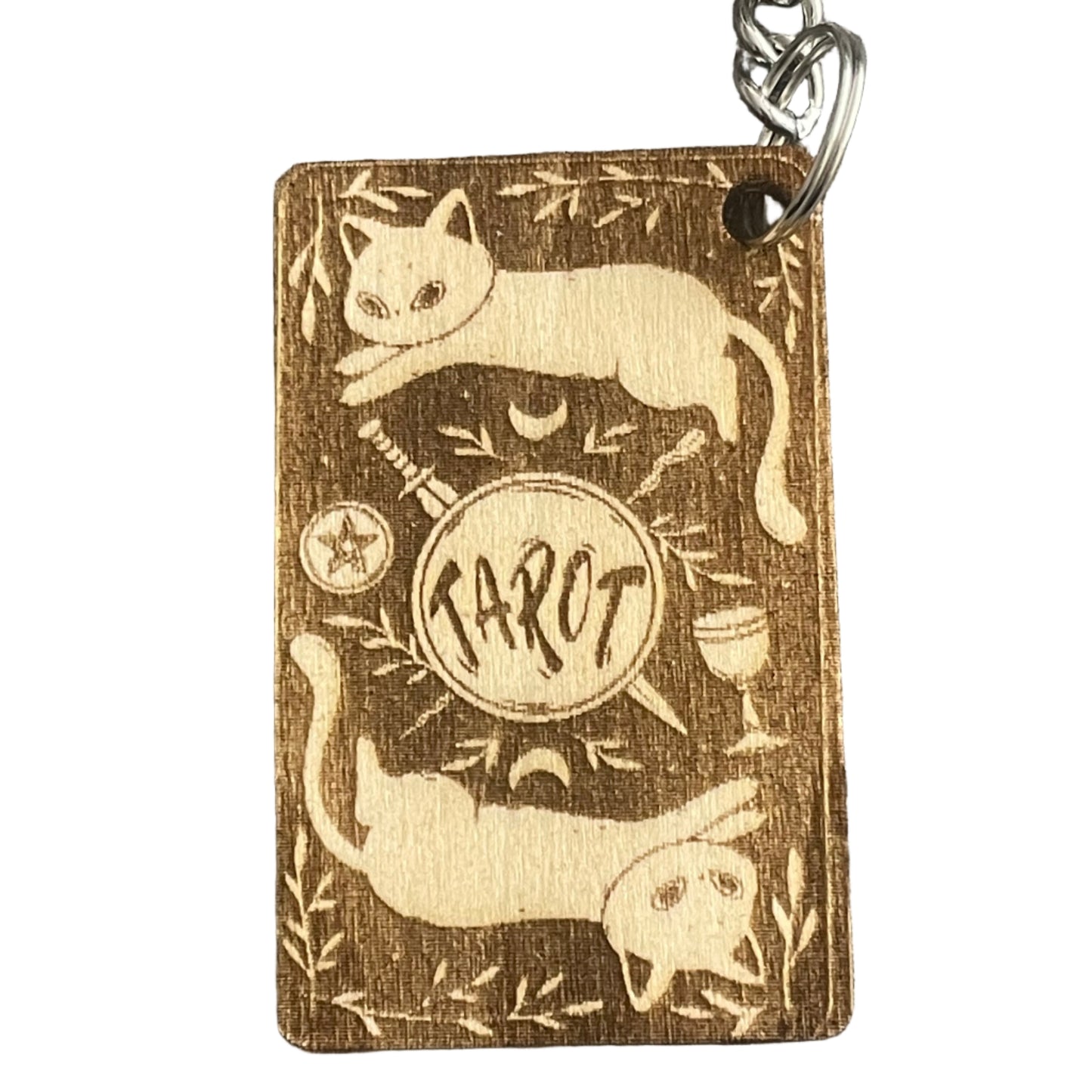 Wooden keychain with cat designs and engraved text on a textured gray background