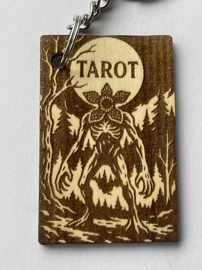 Wooden tarot card with floral design and 'Tarot' engraving on a white background