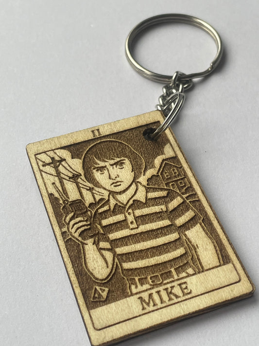 Wooden keychain with engraved design on a gray background