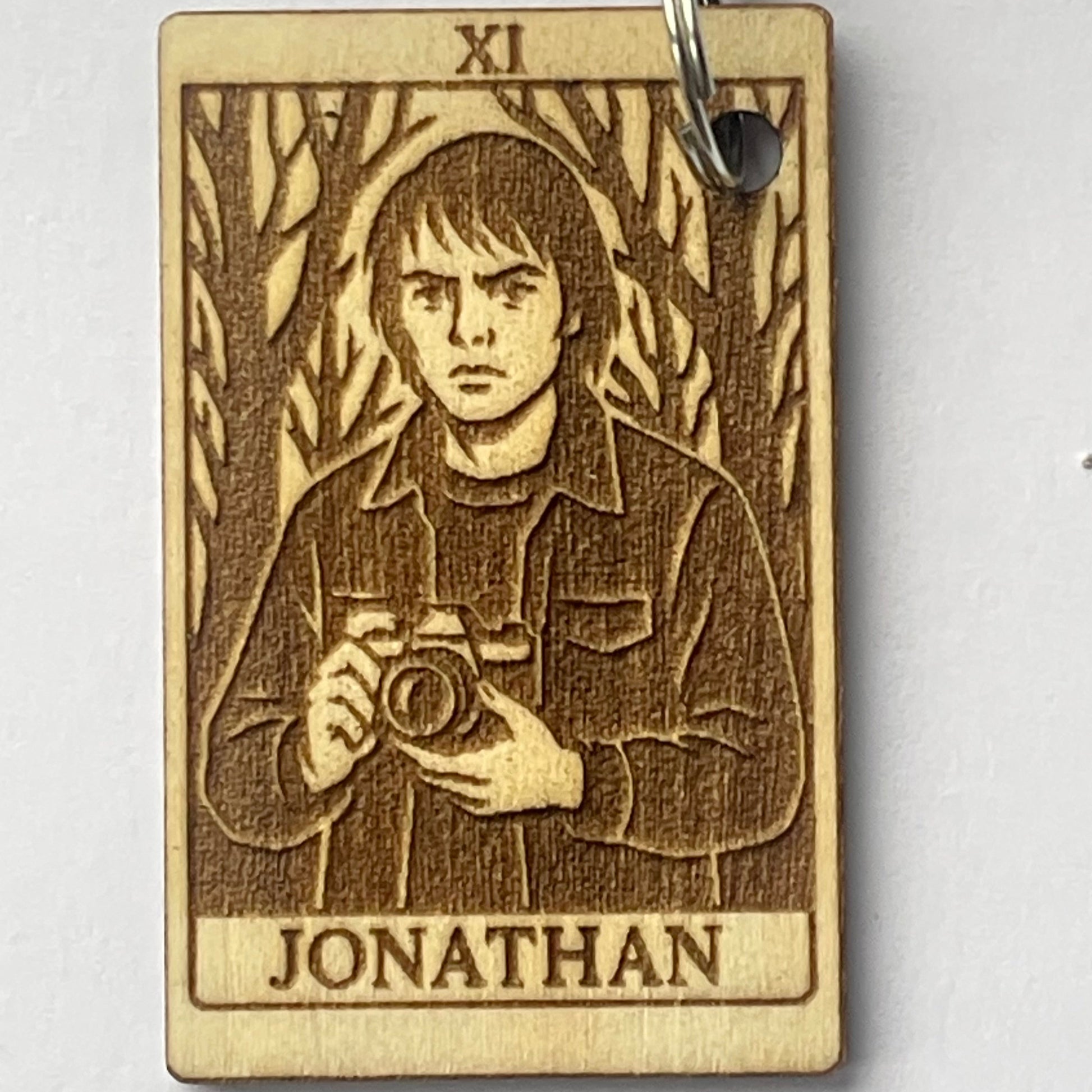 Wooden keychain with engraved design and 'Jonathan' text on a white background