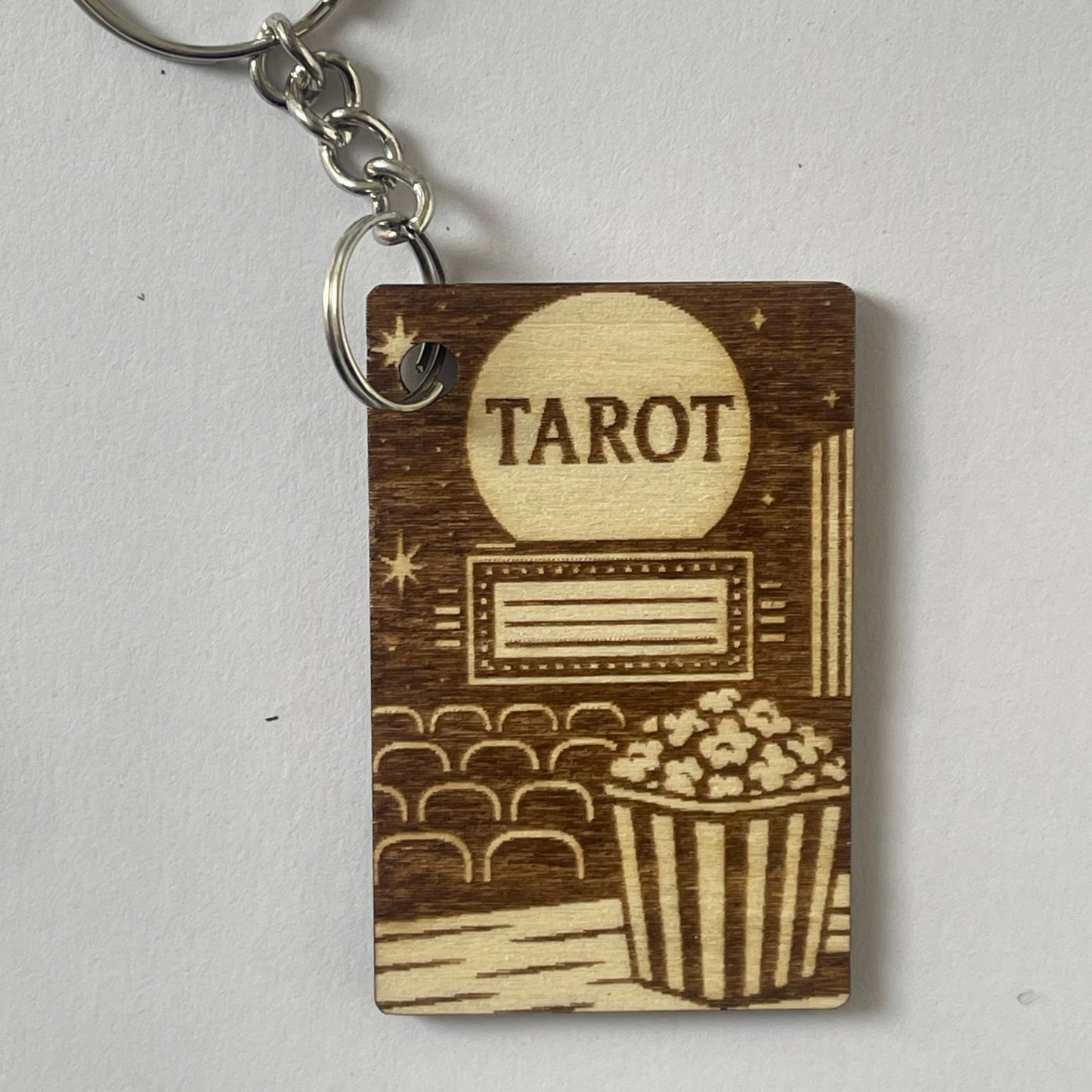 Wooden keychain with 'Tarot' engraving on a light gray background