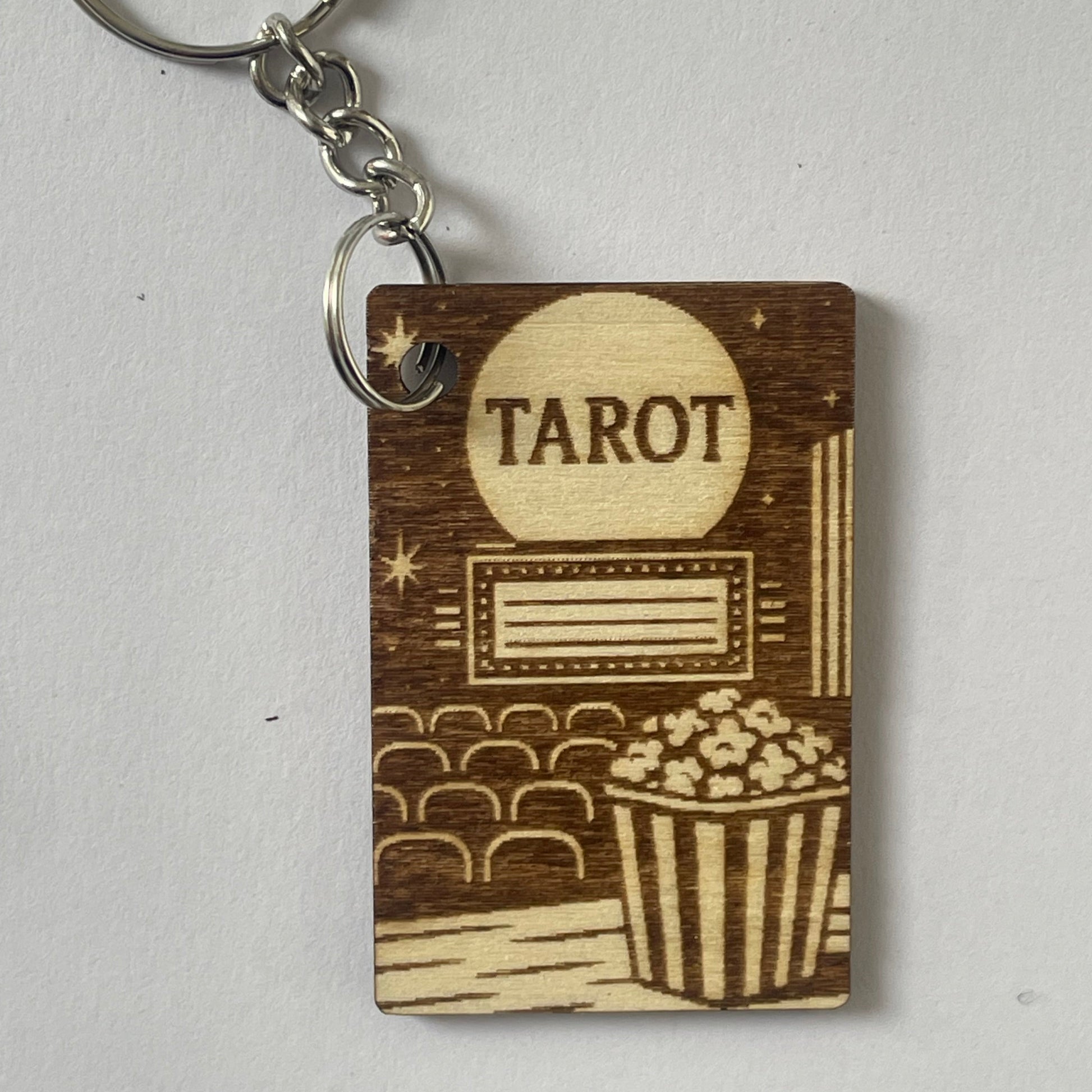 Wooden keychain with 'Tarot' engraving on a light gray background