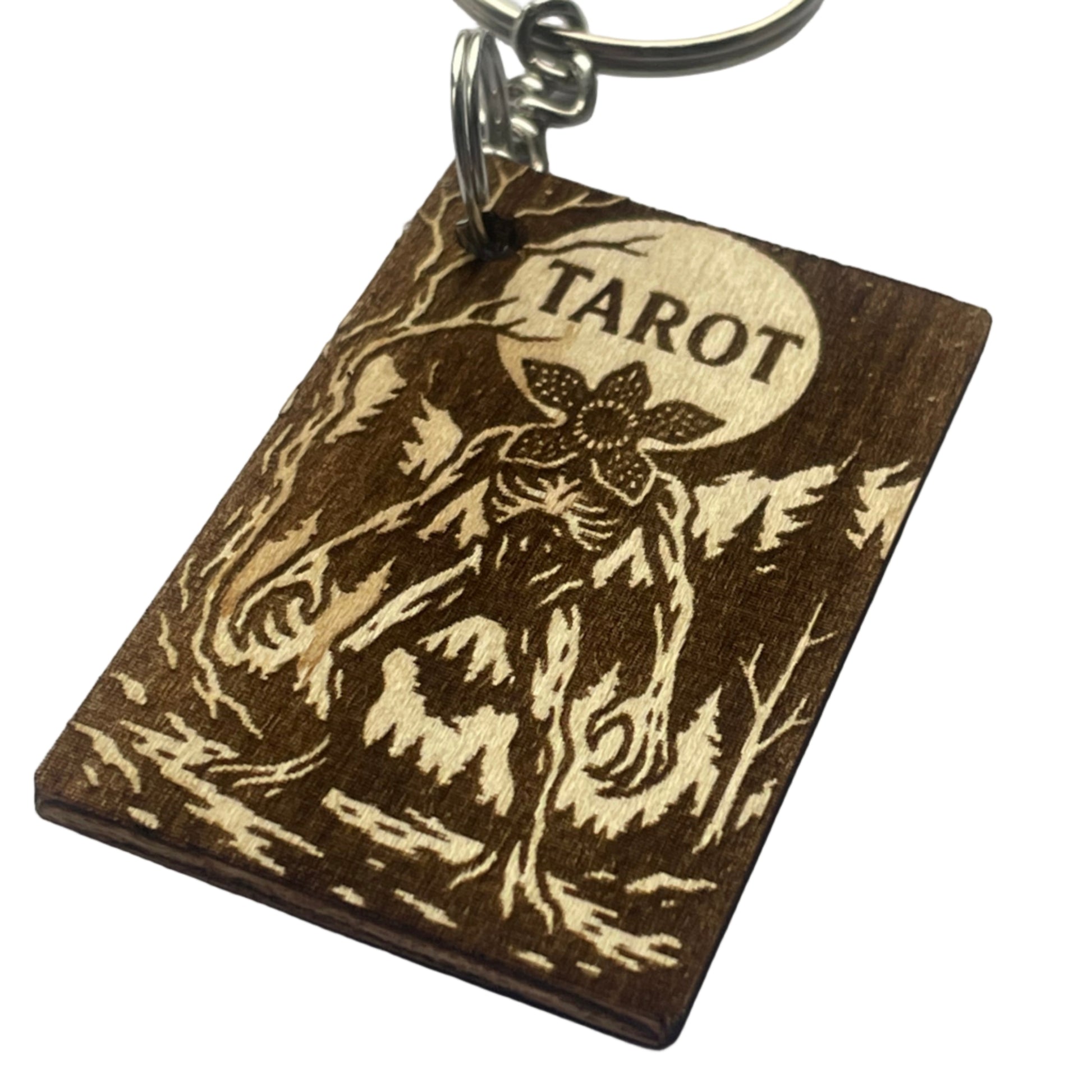 Wooden keychain with 'Tarot' engraving on a gray background