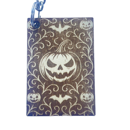 Keychain with Halloween design featuring pumpkins and bats on a brown background.