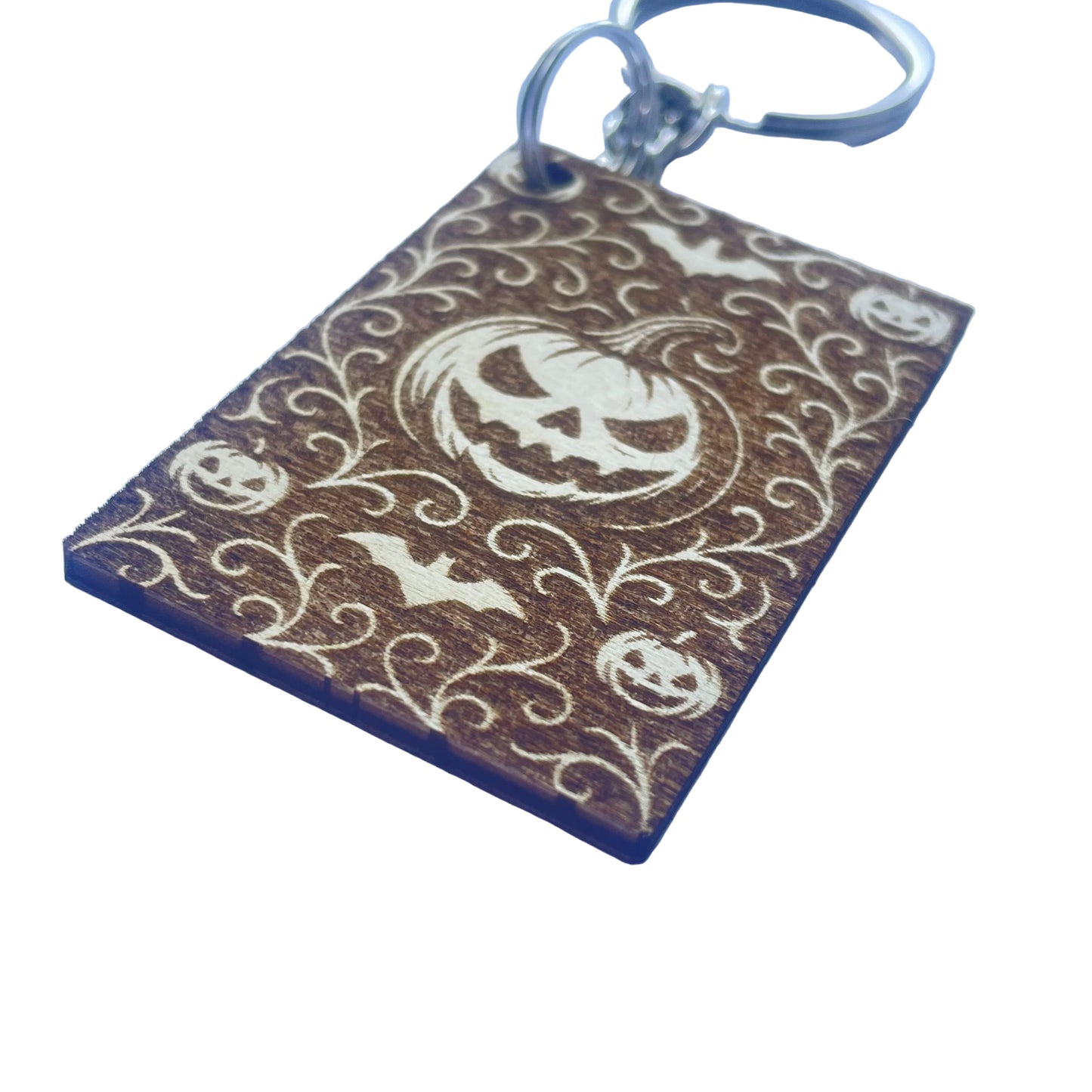 Keychain with Halloween design featuring pumpkins and bats on a brown background.