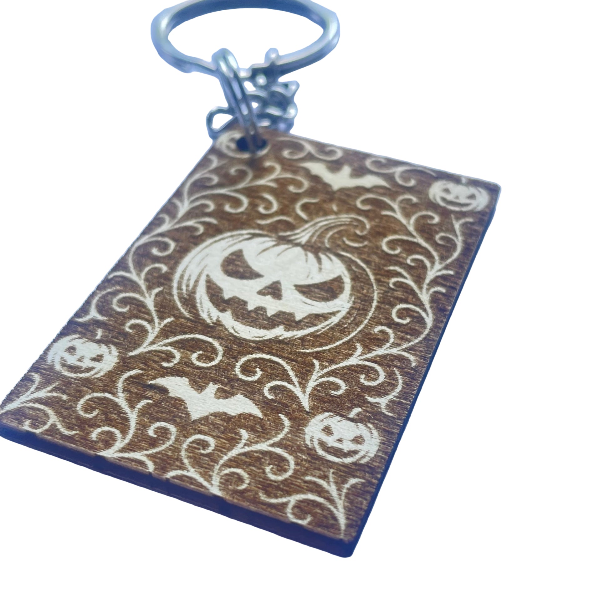 Keychain with Halloween design featuring pumpkins and bats on a wooden background
