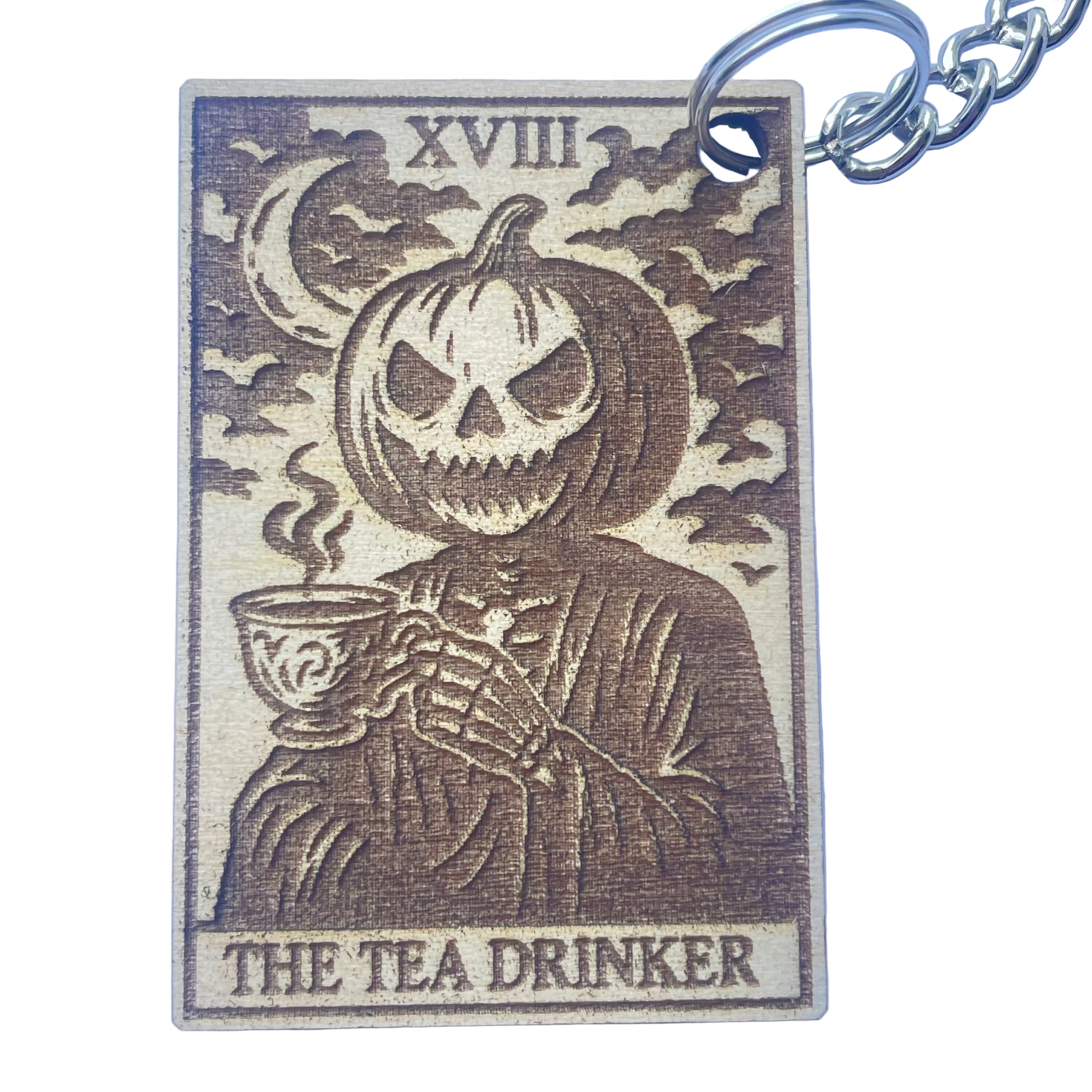 Keychain with a design of a skeleton holding a tea cup, labeled 'The Tea Drinker', on a blue background.