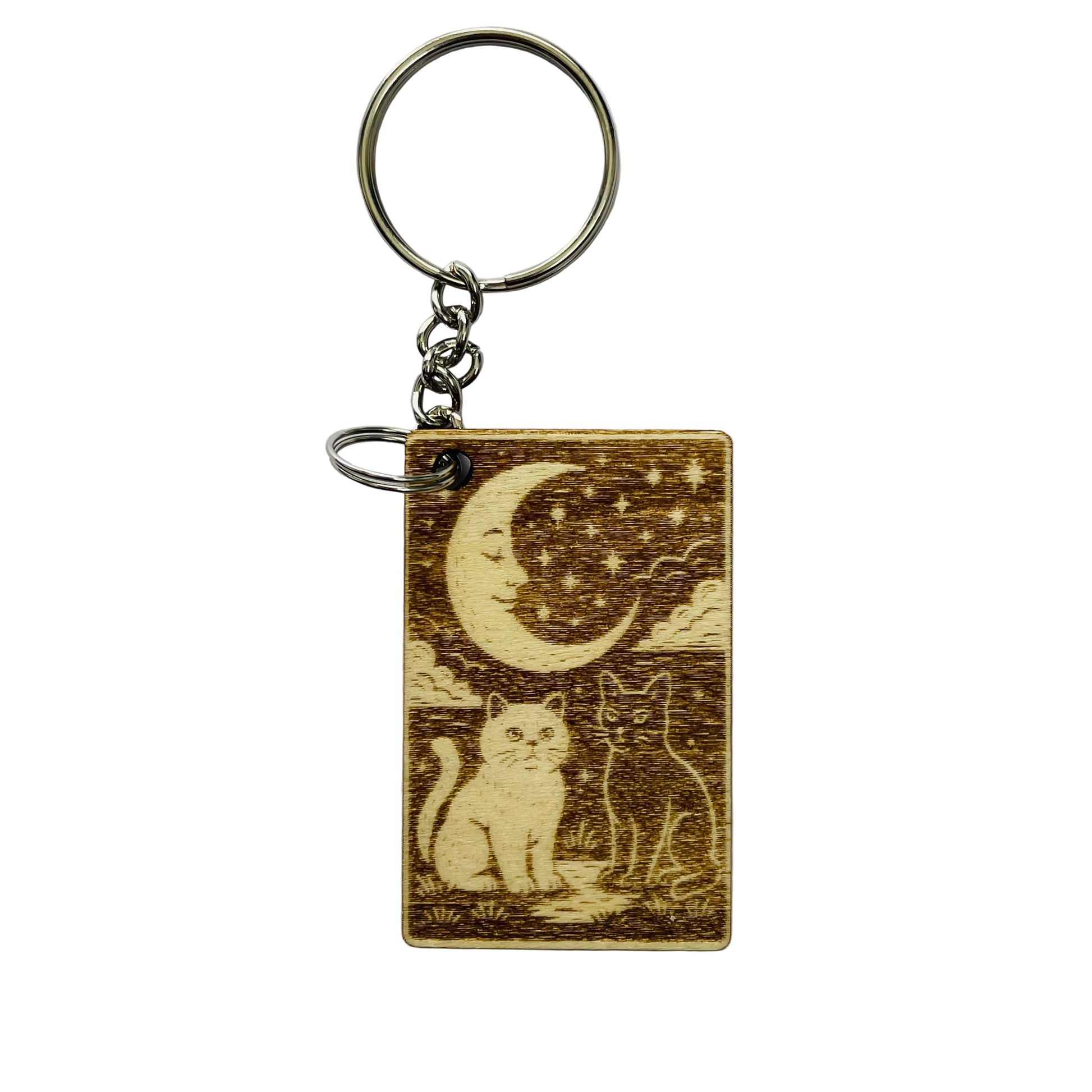 Keychain with engraved design of two cats under a moon and stars on a white background