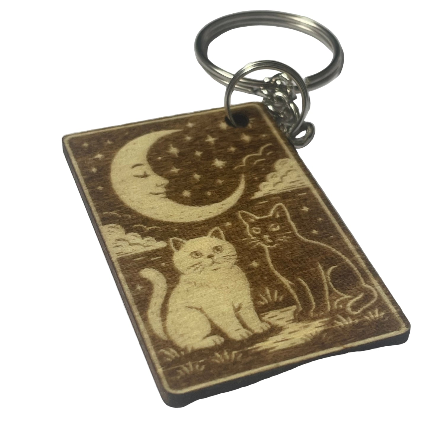 Keychain with engraved design of two cats under a moon and stars on a white background