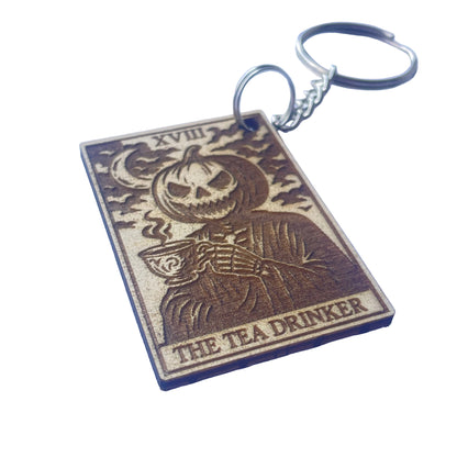 Keychain with skeleton design and 'The Tea Drinker' text on a blue background