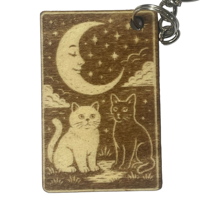 Wooden keychain with cats and a moon design on a white background