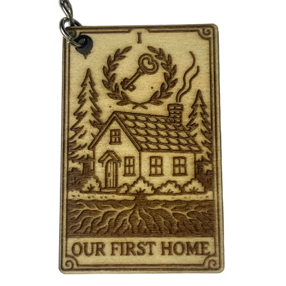 Wooden keychain with engraved house and trees design on a white background