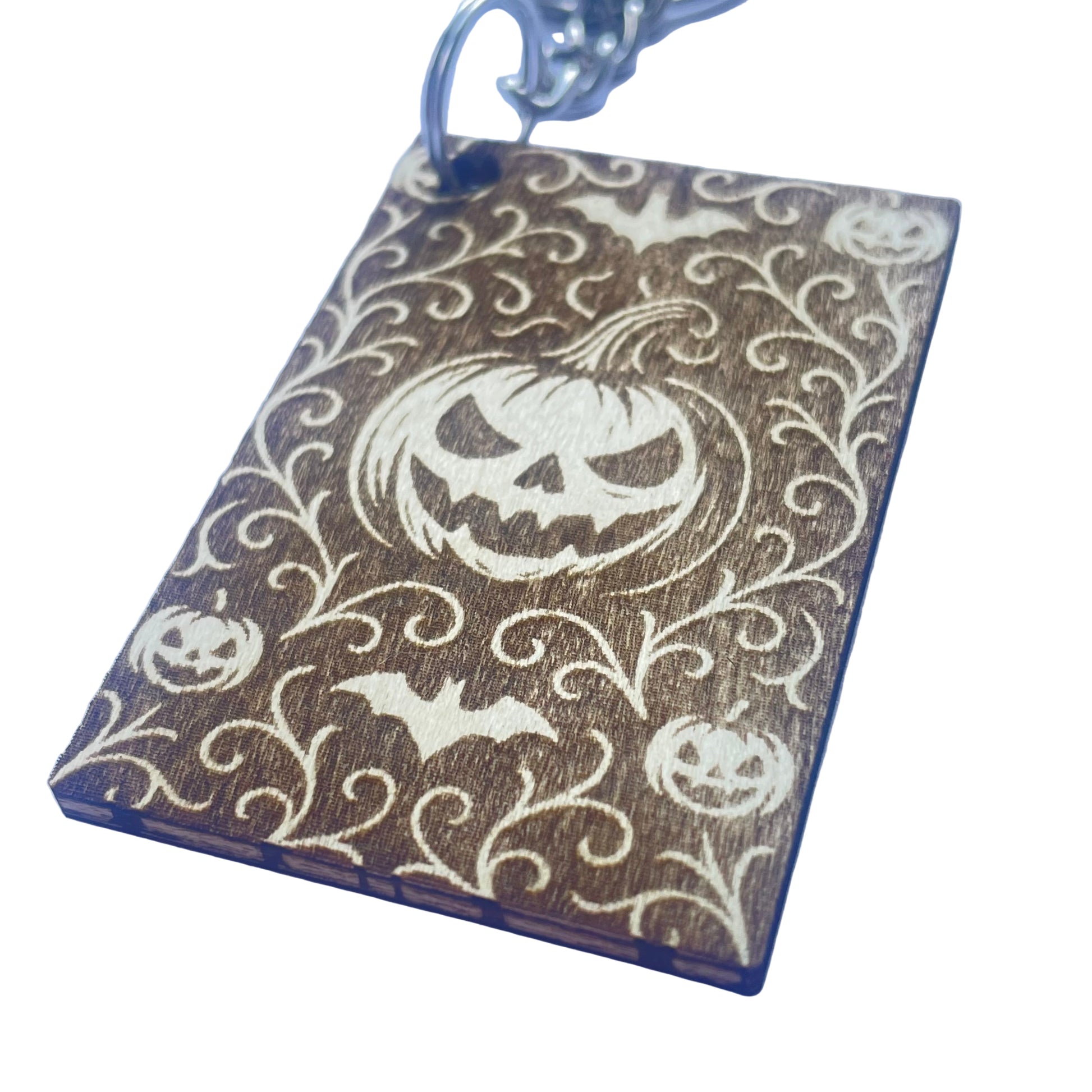 Keychain with Halloween design featuring pumpkins and bats on a blue background