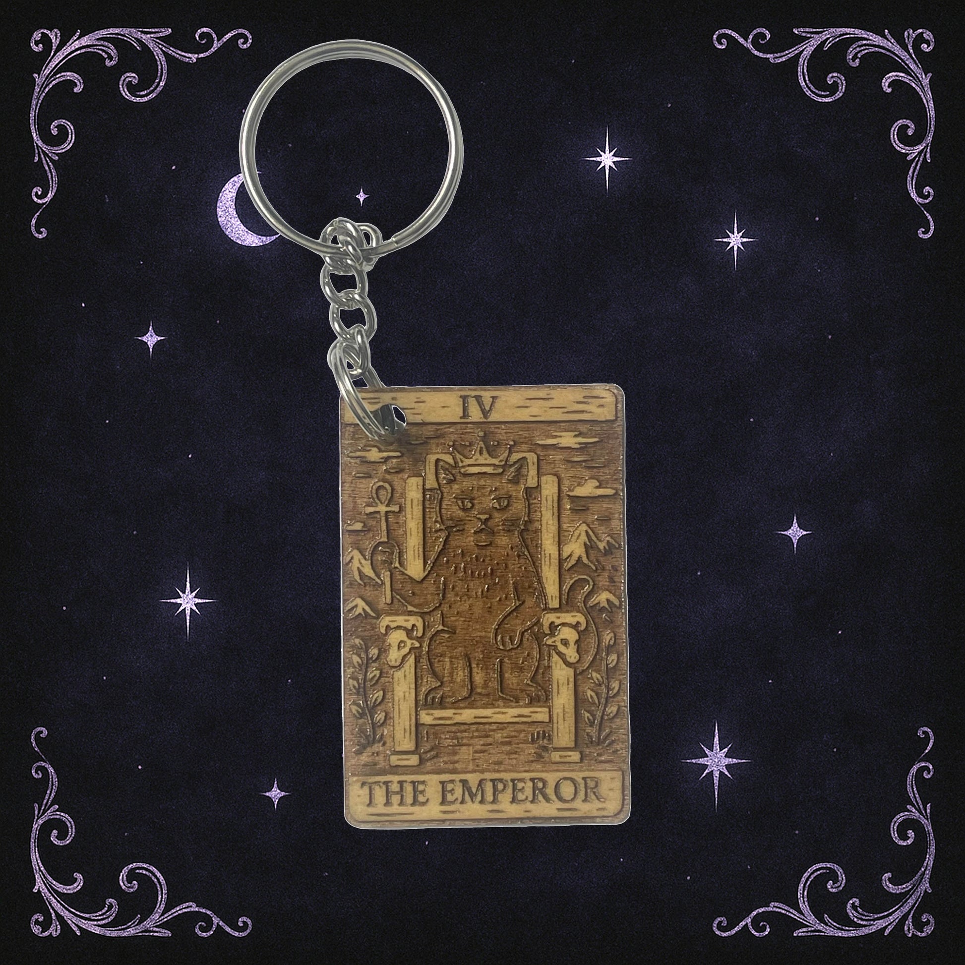Keychain with 'The Emperor' tarot card design on a dark background with stars and moon.