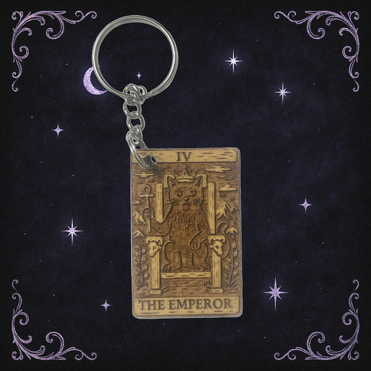 Keychain with 'The Emperor' tarot card design on a dark background with stars and moon.