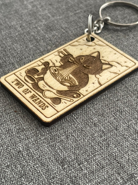 Keychain with 'Two of Wands' tarot card design on a gray textured background