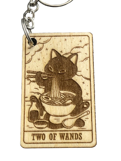 Wooden keychain with tarot card design featuring a cat and 'Two of Wands' text on a gray background.
